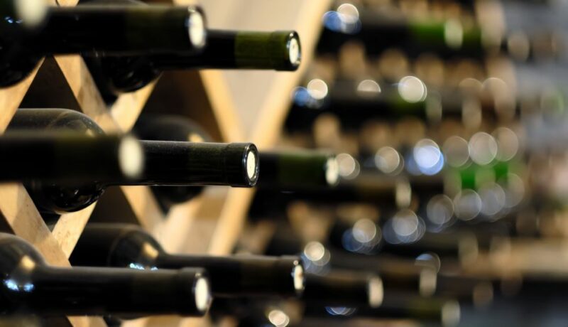 Resting,Wine,Bottles,Stacked,On,Wooden,Racks,In,Cellar