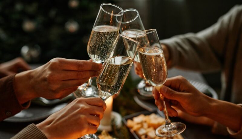 Close,Up,Of,Four,People,Enjoying,Christmas,Dinner,Together,And